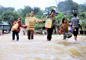 Girls collecting fresh water during floods. Cover image for blog post on gender-responsive climate finance.