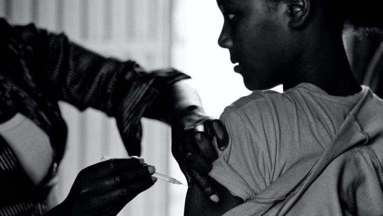 Cover photo for article on life-saving medications for Africans and IP Reform. Photo of young woman getting a vaccine.